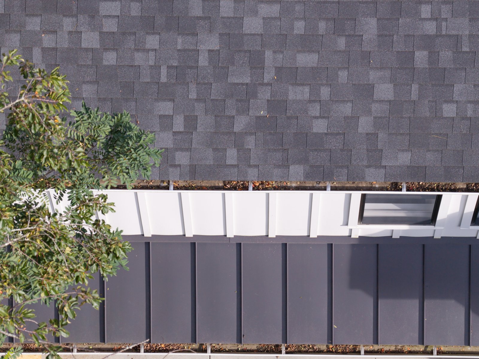 Overhead SPARVERIUS drone inspection showing debris along both gutters of a residential roof